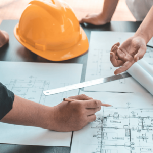 Construction workers review plans for a house