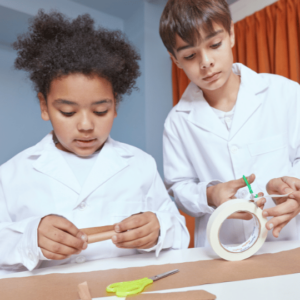 Young students studying science using paper and tape