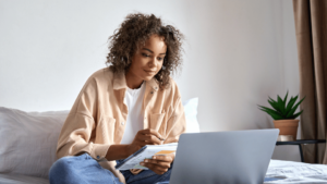 Woman learning remotely at home using VIVED Learning on a laptop