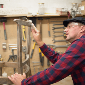 A man sanding a chair in a carpentry lab