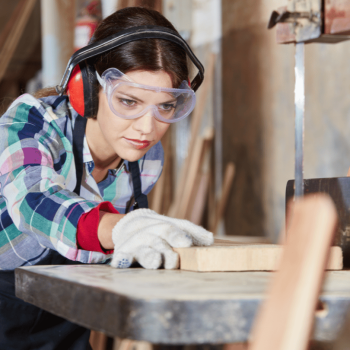A carpentry student in a carpentry lab using a power tool
